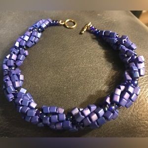 Purple twisted bead bracelet. Goldtone toggle closure. 9 1/2 inches in length
